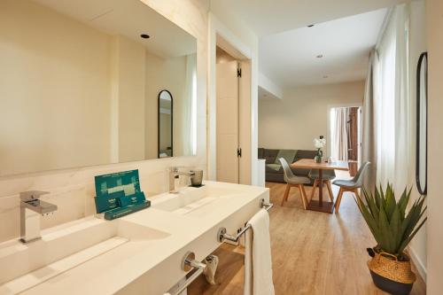 a white bathroom with two sinks and a table at Apartamentos Silken Fontibre Iberia & Spa in Nestares