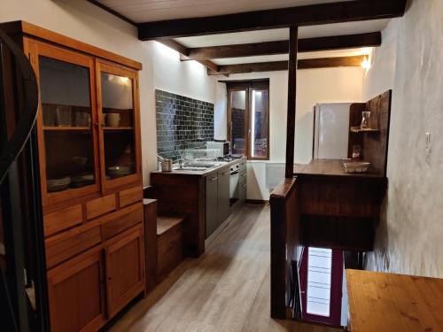 a large kitchen with wooden cabinets and a sink at Maison Nannings in Seix