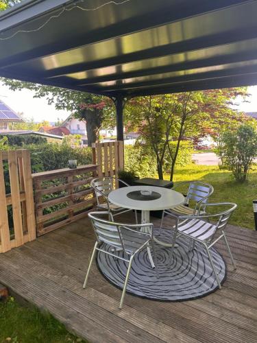 a patio with a table and chairs on a deck at Apartment Rosi SECONDO in Reisbach