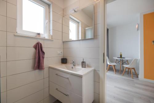 bagno con lavandino e specchio di Guesthouse Halilagic a Krk