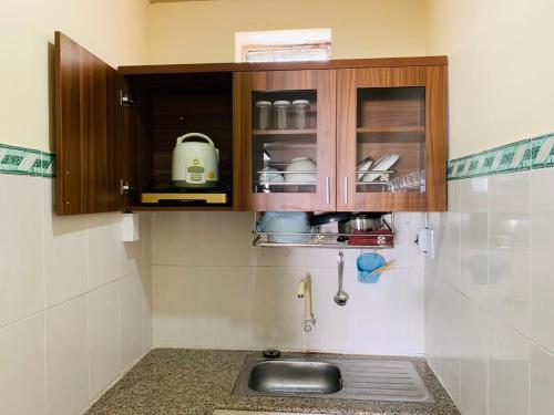 a kitchen with a sink and wooden cabinets at Lam Son Hotel in Vung Tau