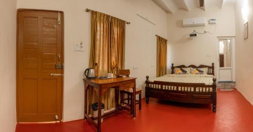 een slaapkamer met een bed en een houten deur bij Parambara Heritage in Pondicherry