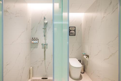 a bathroom with a glass shower with a toilet at Holiday Inn Express Nanjing Riverside by IHG in Nanjing