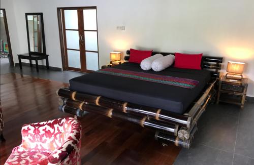 a bedroom with a large bed with red pillows at Villa Rizki Candidasa in Candidasa
