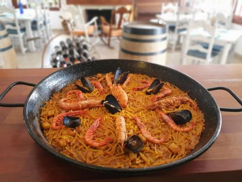 a pan of food with shrimp on top of pasta at Hostal Mi Campaña in Denia