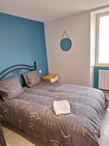 una camera con un letto con una parete blu di Gite Le Pigeonnier a Miers