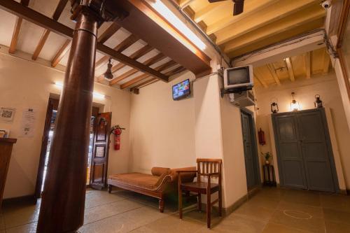 ポンディシェリにあるParambara Heritageのリビングルーム(テーブル、壁掛けテレビ付)