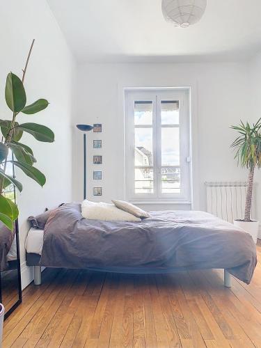 un lit dans une chambre blanche avec une fenêtre dans l'établissement Spacieux T3 80m2 plein centre presque ile !, à Lyon