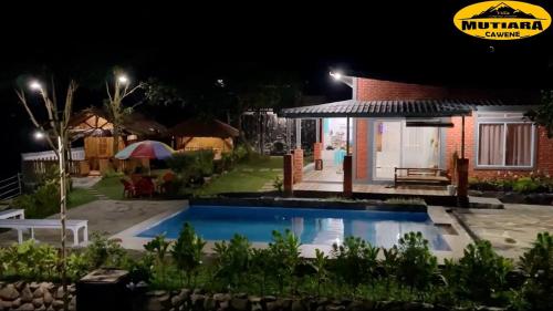 a villa with a swimming pool at night at Villa Mutiara Cawene in Gunungpicung