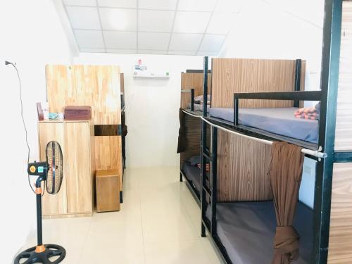 a room with two bunk beds and a fan at Codohomestay Garden in Hue