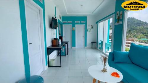 a living room with a blue couch and a table at Villa Mutiara Cawene in Gunungpicung