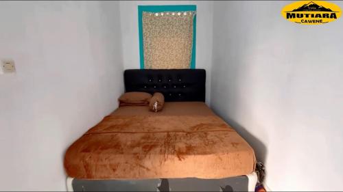 a bed in a corner of a room at Villa Mutiara Cawene in Gunungpicung