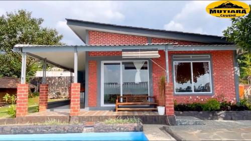 a small red brick house with a bench in front at Villa Mutiara Cawene in Gunungpicung