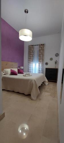 ein Schlafzimmer mit einem großen Bett in einem Zimmer in der Unterkunft El piso de Manuel in Sanlúcar de Barrameda