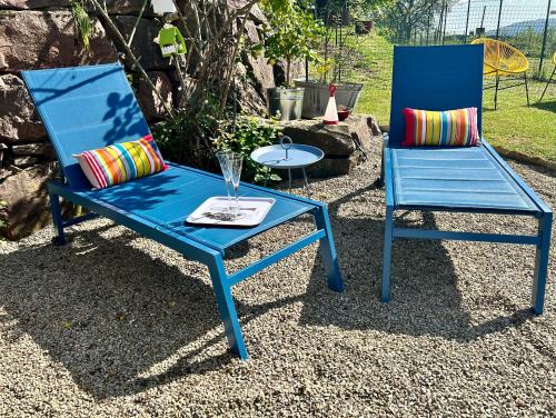 2 Stühle, ein blauer Stuhl und ein Tisch in der Unterkunft Ferienwohnung Piesbach in Nalbach