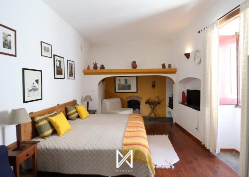 a bedroom with a large bed with yellow pillows at MyStay - A Casa do Visconde in Mértola