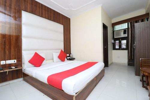 1 dormitorio con 1 cama grande con almohadas rojas en Hotel Airport land, en Nueva Delhi