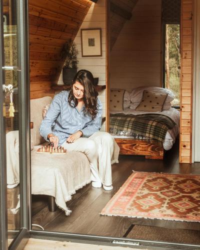 a woman sitting on a chair playing chess at Tempo Manor Cabins in Tempo