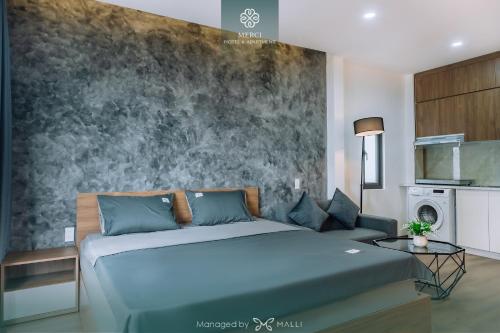 een slaapkamer met een blauw bed en een muur bij Merci Hotel & Apartment - Le Hong Phong, Hai Phong in Hai Phong
