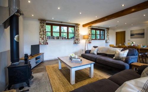 a living room with a couch and a stove at Oak Tree Cottage in Lydney