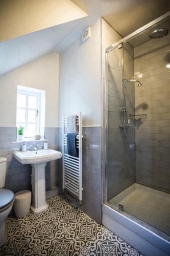 a bathroom with a shower and a sink and a toilet at Oak Tree Cottage, Countryside Retreat with River View in Lydney