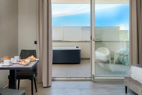 - un salon avec une table et une vue sur une baignoire dans l'établissement Emerald Hotel Residence Cefalù, à Cefalù