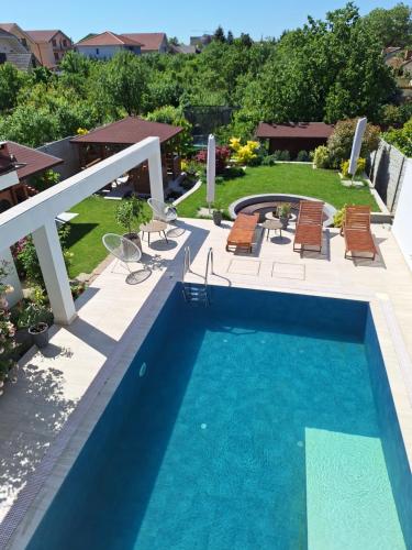 a swimming pool in a yard with chairs at TREND - cazare, gradina, piscina in Arad