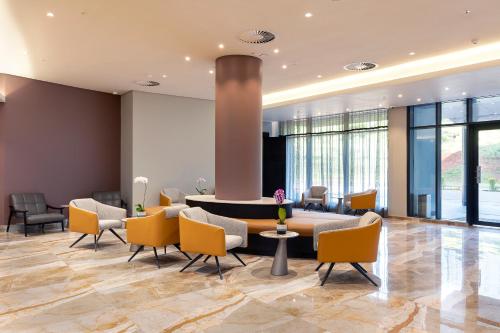 a lobby with yellow chairs and a round table at Coastlands Skye Hotel, Ridgeside, Umhlanga in Durban