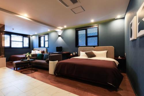 a bedroom with a bed and a couch at Brown Dot Yangjeong in Busan