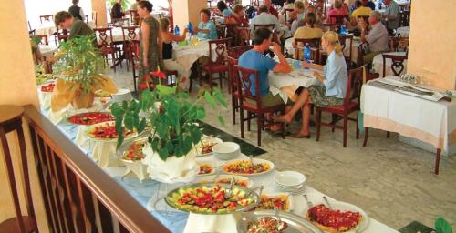 博薩的住宿－Malaspina Hotel & Resort，一群坐在餐桌上的人,拿着食物盘