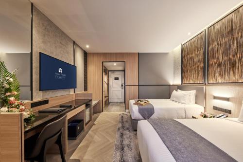 a hotel room with two beds and a desk at Hotel Royal Signature in Kuala Lumpur