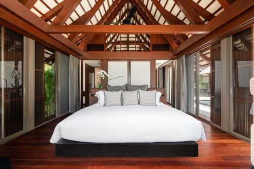 a bedroom with a large white bed and large windows at Villa Akatsuki in Lipa Noi