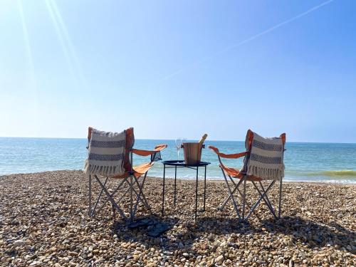 two chairs and a table on a beach at Stunning 2 Bed Apartment Sea Views and Parking in Worthing