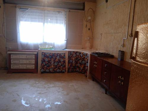 uma cozinha com um lavatório e uma janela em Jean d’arc em Skikda