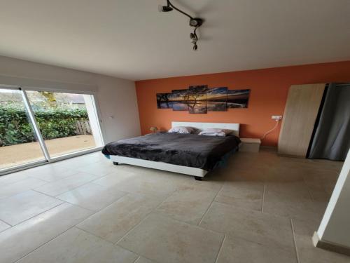 1 dormitorio con cama y pared de color naranja en Gite De La Petite Fontaine 