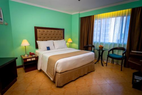 a hotel room with a bed and a window at Royal Bellagio Hotel in Manila