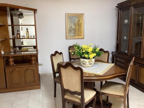 a dining room table with a vase of flowers on it at La Casa per te in Pescara