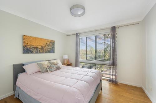 a bedroom with a large bed and a large window at 5 bedroom Terrigal beach home with district views in Terrigal