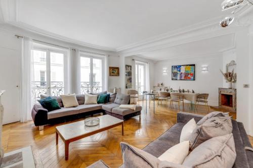 un salon avec deux canapés et une table dans l'établissement Luxurious Flat Champs Elysée, à Paris