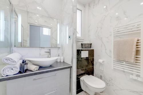 une salle de bain blanche avec un lavabo et des toilettes dans l'établissement Luxurious Flat Champs Elysée, à Paris