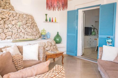 a living room with blue doors and a couch at Villa La Samia in Torricella