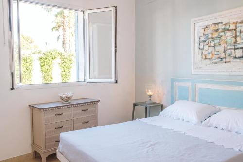 a bedroom with a white bed and a window at Villa La Samia in Torricella
