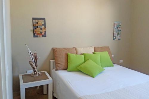 a bedroom with a bed with green pillows on it at Villa La Samia in Torricella