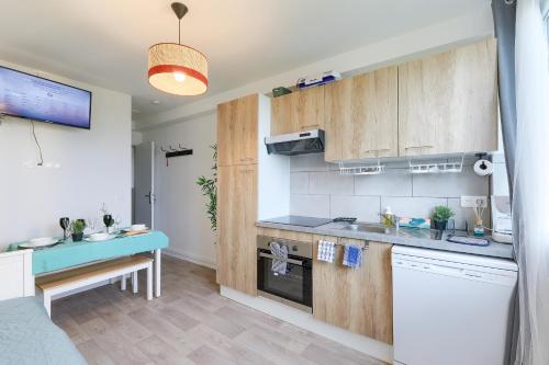 une cuisine avec des placards en bois et un comptoir bleu dans l'établissement Appart Spacieux pour 6, Vue Panoramique, à Saint-Denis