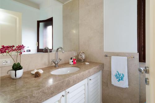 a bathroom with a sink and a mirror at Cala Mancina in San Vito lo Capo