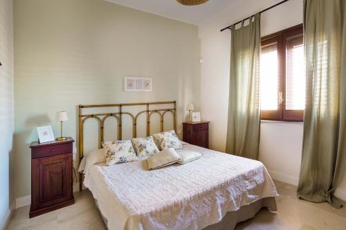 a bedroom with a large bed and a window at Cala Mancina in San Vito lo Capo