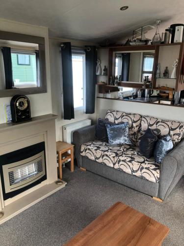 sala de estar con sofá y chimenea en Eyemouth getaway, en Eyemouth