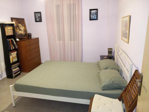Schlafzimmer mit einem Bett mit grüner Tagesdecke in der Unterkunft Giannis country house in Palaiokómi