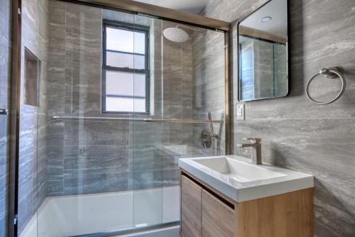 ein Bad mit einem Waschbecken und einer Dusche in der Unterkunft Blueground East Village elev wd near park NYC-1462 in New York
