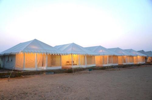 una fila de tiendas están alineadas en un campo en Jaisalmer Night Safari Camp en Jaisalmer